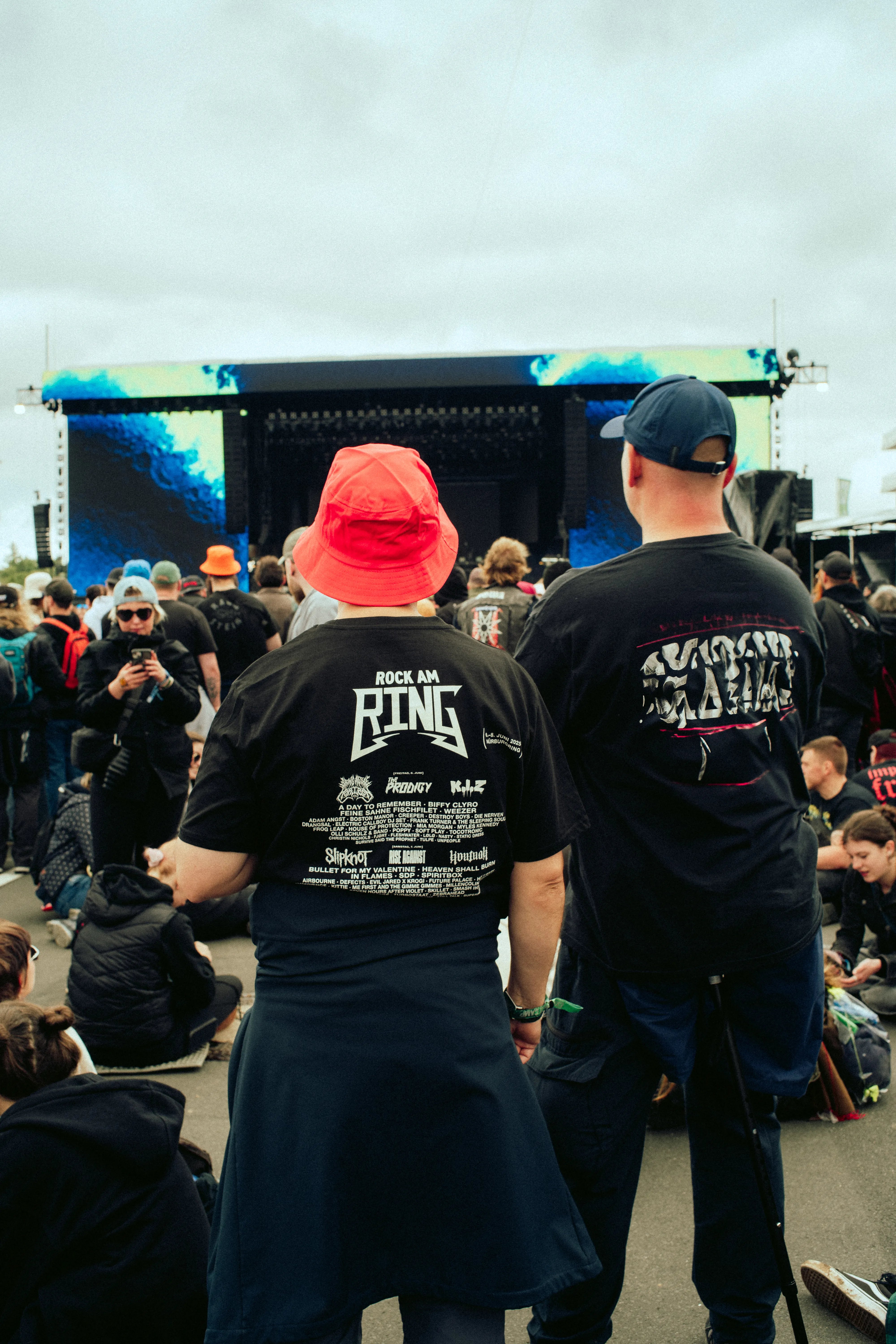 Fans Rock am Ring 2025 vor Bühne mit aktuellem Line Up Shirt